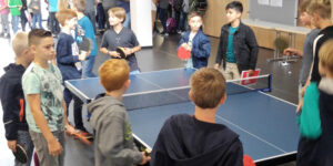 Mehrere Kinder und Jugendliche spielen Rundlauf um eine Tischtennisplatte