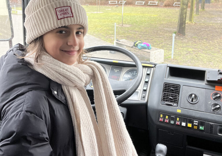 Ein Mädchen sitzt in einem Feuerwehrauto