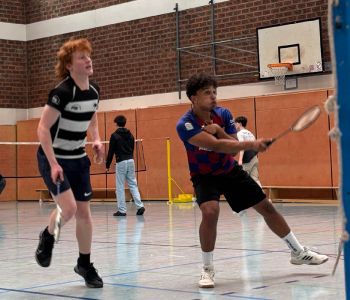 Zwei Jungs spielen Badminton.