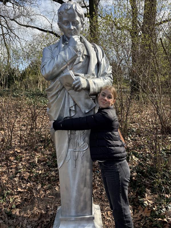 Eine Schülerin umarmt eine Statue