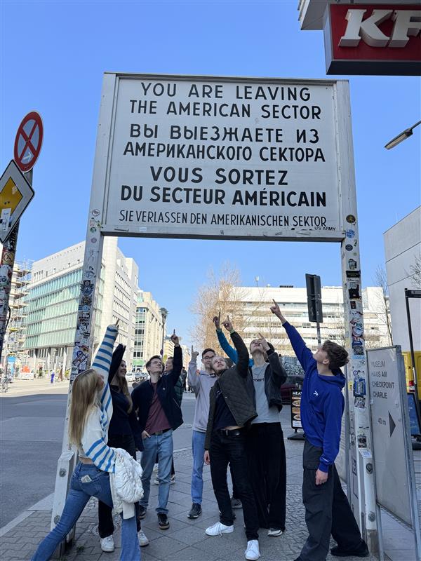 Schülerinnen und Schüler zeigen auf ein Schild in Berlin
